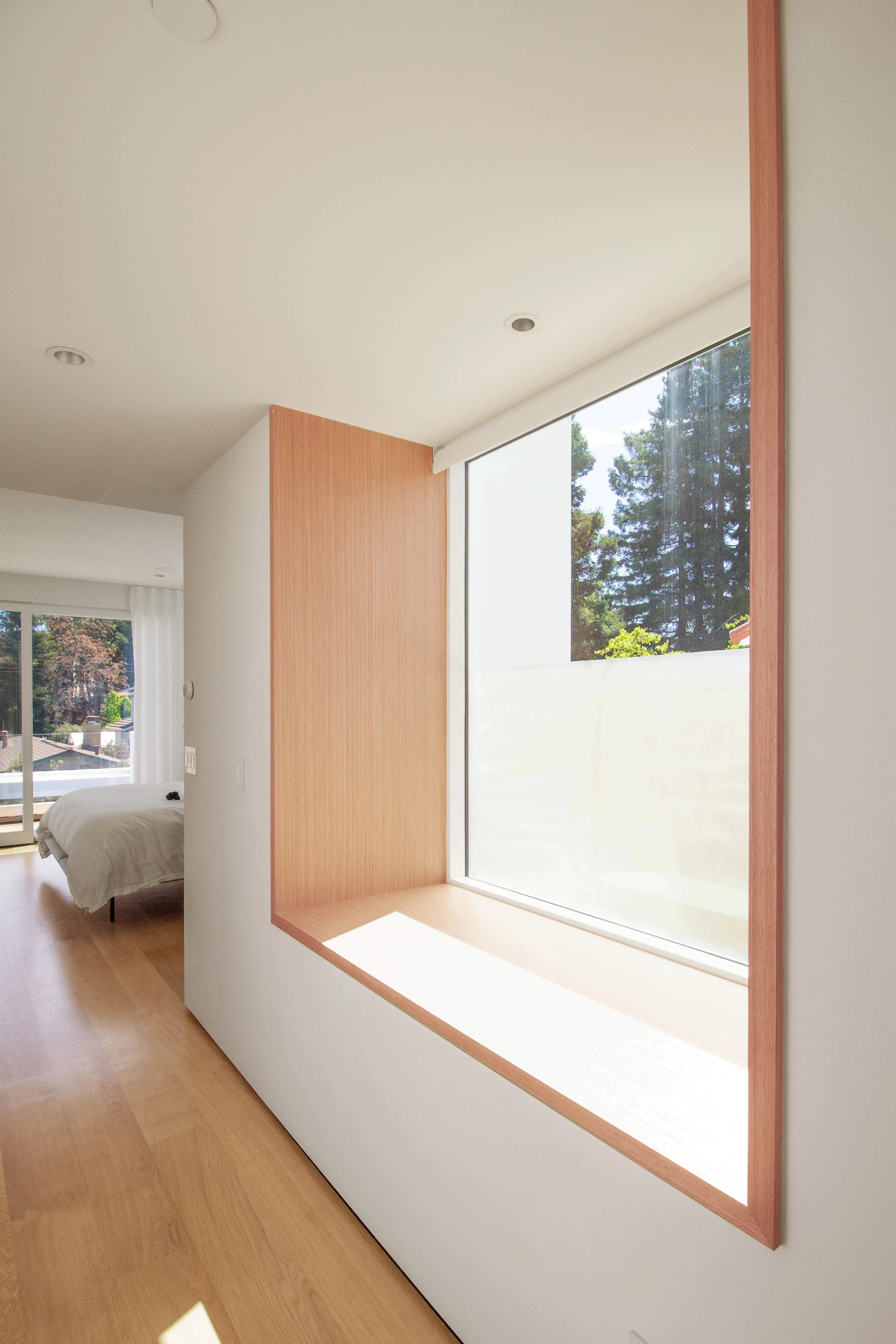 Bay window seat framed in cedar, with sunlight falling across the bench