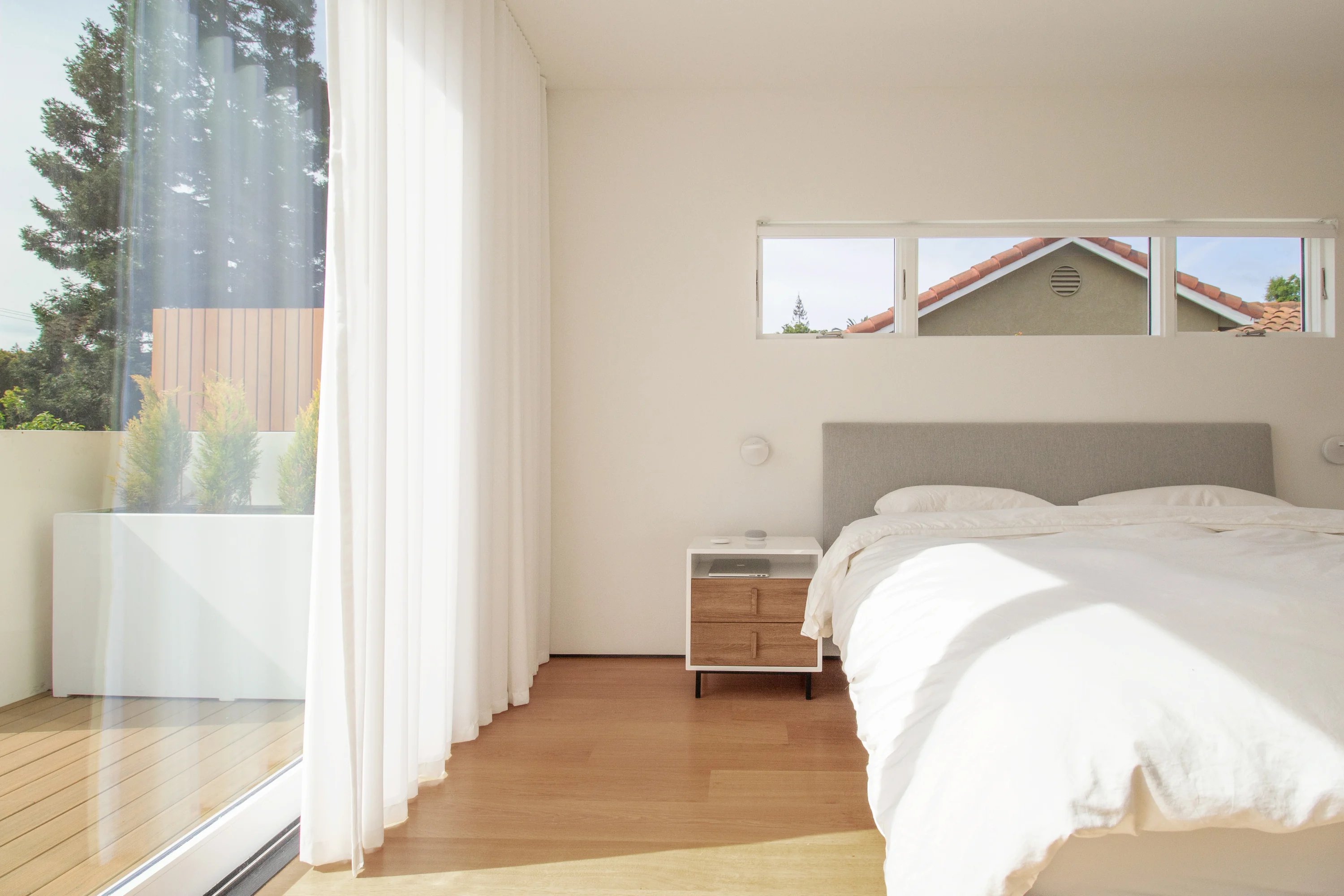 Primary bedroom with natural light and warm white oak flooring